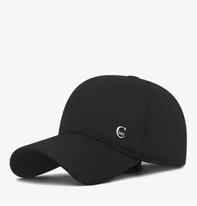 Detail view of winter baseball cap featuring silver metal letter C and warm fabric texture