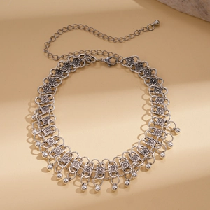 Detail of bohemian silver choker with floral metal plates and hanging bead fringe charms