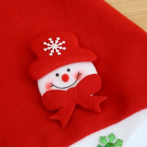 Macro detail of red felt Christmas stocking featuring 3D snowman and snowflake applique
