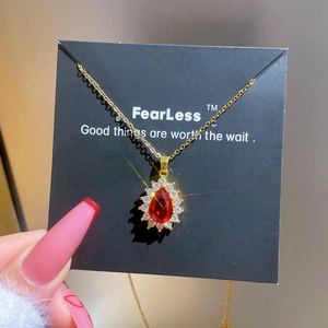 Luxurious gold stainless steel necklace with a pear-cut ruby pendant and micro-set diamonds