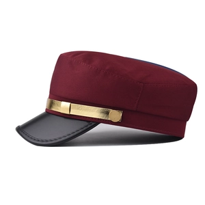 Détail de la casquette marin bordeaux avec visière en cuir noir et chaîne en métal doré