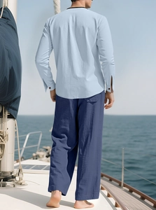 Linen long sleeve shirt and navy wide trousers on boat deck with sea view