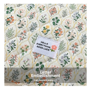 Close-up of quilted floral fabric and woven label on a 13-inch laptop sleeve