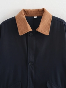 Close-up of a navy work jacket collar with brown corduroy and a size S label