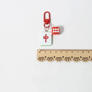 Dettaglio di un portachiavi Mahjong creativo con chiusura rossa e ciondolo dado