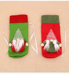 Detail of red and green Christmas wine bottle covers with gnome figures and drawstrings