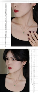 Detail of 18K gold plated jewelry set with round cut emerald and ruby gemstones
