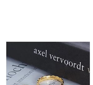 Vista dettagliata di un anello dorato con trama a onde su libri artistici