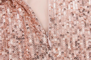 Detailed macro view of rose gold sequins on mesh fabric with matching hidden zipper