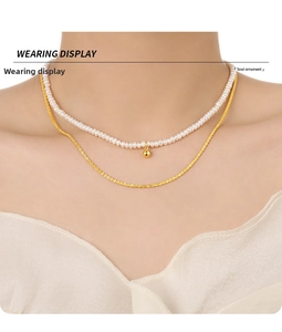 Elegant double layered necklace with freshwater pearls and gold beads on a female model