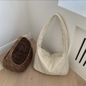 Detailed close-up of quilted cream-white puffer tote bag with soft padded texture