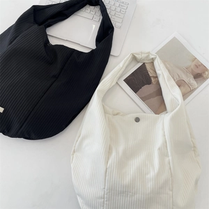 Détail de sacs fourre-tout en tricot noir et blanc avec texture côtelée et bouton métal