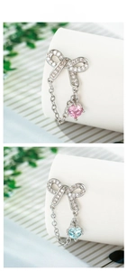 Detail of 925 silver bow earrings featuring pink and blue zircon stones on marble display