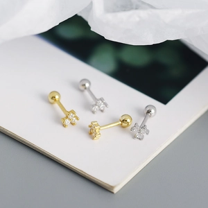 Close-up of gold and silver S925 floral stud earrings with tiny sparkling zircons