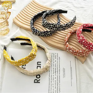 Detailed embroidery of floral patterns on multi-colored knotted fabric wide headbands