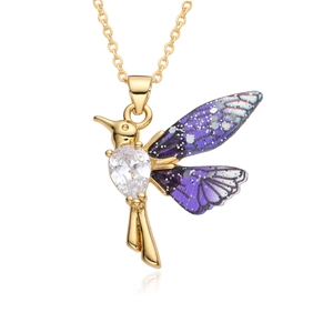 Macro detail of hummingbird pendant with gold plating, purple wings and zircon stone