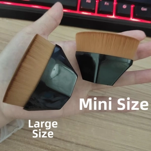 Comparison of large and mini foundation brushes with dense bristles and black mirror handles