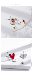Detailed tile display of heart stud earrings with red gems and enamel texture