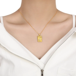 Textured gold square pendant necklace with small diamonds on model with white background