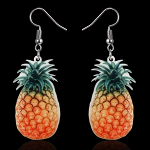 Detail shot of pineapple earrings with hooks showing vibrant yellow fruit textures on black
