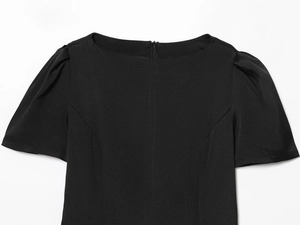 Détail de la robe courte noire avec col rond, manches bouffantes et fermeture éclair