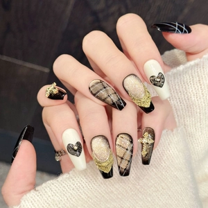 Handmade press-on nails featuring black and gold lattice heart cross in long coffin shape
