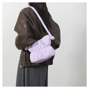 Detail view of a light purple puffy down shoulder bag with soft quilted nylon texture
