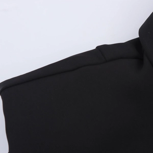Close-up detail of padded shoulder stitching on the black sleeveless commuter dress
