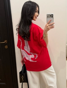Close-up of pink leopard print pattern on the back of this loose red cotton t-shirt