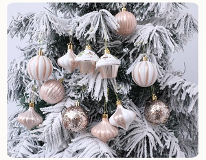 Close-up of champagne and pink festive ornaments on a snow-covered Christmas tree