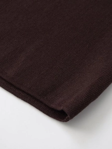 Dettaglio ravvicinato della trama in maglia fine del vestito midi marrone scuro