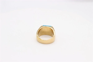 Detail view of the smooth inner band and polished gold finish of the square turquoise ring