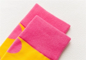Macro detail of combed cotton knit socks with yellow polka dots and ribbed cuff design