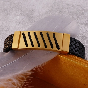 Detail eines schwarzen Lederarmbands für Herren mit goldenem Edelstahlelement