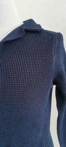 Detailed close-up of dark blue waffle knit texture and stand collar of a men's cardigan
