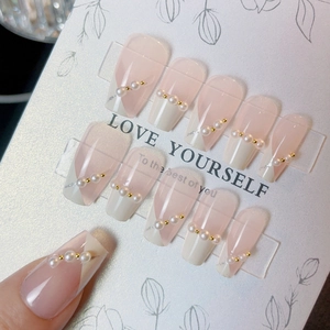 Pink and white French press-on nails with delicate pearl and gold bead accents