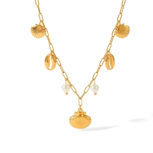 Detail of gold seashell necklace with cowrie charms and pearls on paperclip chain