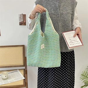 Detailed close-up of green tweed knit texture on a large capacity tote bag