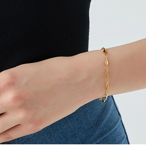 Detail of 18K gold-plated geometric diamond-shaped bracelet on woman's wrist