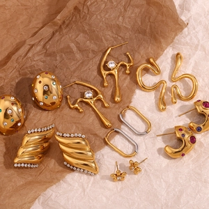 Macro shot of gold-plated liquid lava earrings with cubic zirconia on vintage paper