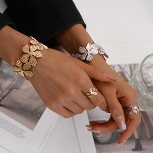 Detail of two-piece textured flower cuff bracelet set in gold and silver finish