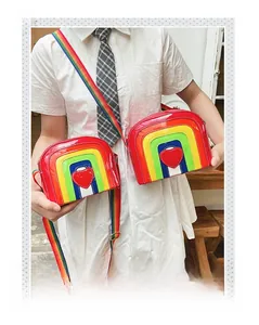Detail of rainbow crossbody bag featuring shiny patent leather and red heart patch