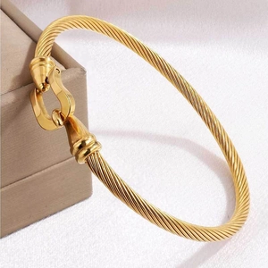 Elegant gold-tone twisted cable bracelet with a classic horseshoe buckle for women