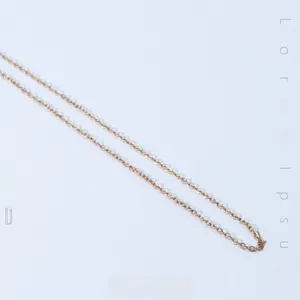 Detail of rose gold snake chain necklace featuring polished small interlocking rings