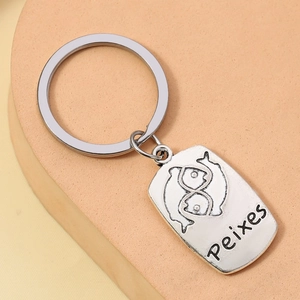 Detailed close-up of silver Pisces zodiac keychain with symbol and Peixes engraving