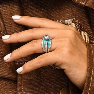 Close-up of vintage silver ring with large round stone and teal enamel detailing