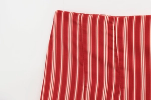 Macro view of red and white vertical stripes on the soft woven fabric of the dress