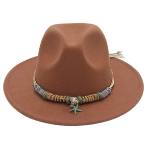 Dettaglio cappello fedora in lana marrone con fascia intrecciata e ciondolo a stella marina
