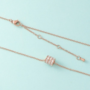 Macro detail of rose gold pendant with triple row crystals and adjustable lobster clasp