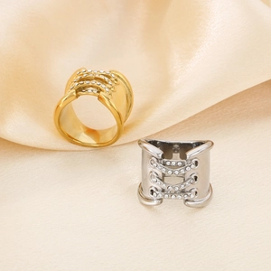 Macro detail of criss-cross corset style 18K gold plated rings with micro zircons on silk